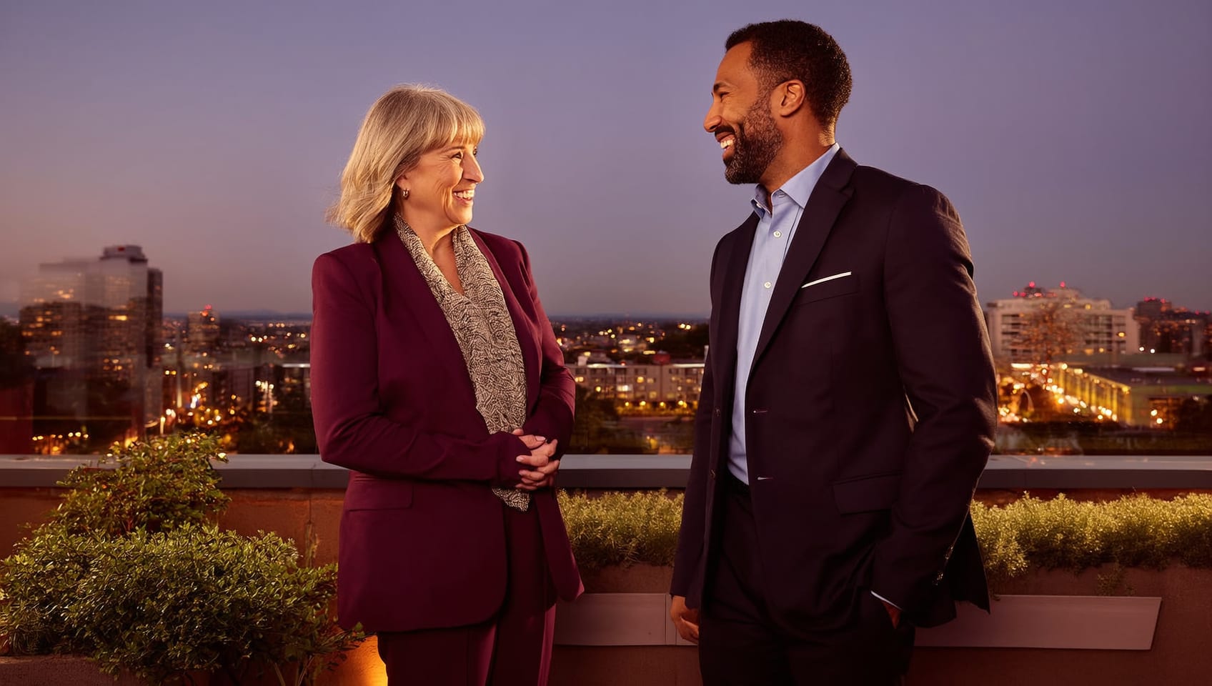 Investment partners in conversation on a terrace above the evening city
